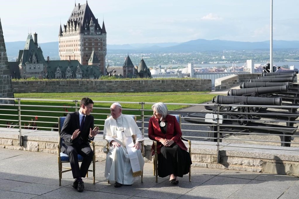 Pope Francis talks with Gov. Gen. Mary Simon, right, and Prime Minister Justin Trudeau, left, as they prepare to pose for a photo after arriving at the Citadelle during his papal visit across Canada in Quebec City on Wednesday, July 27, 2022. THE CANADIAN PRESS/Nathan Denette