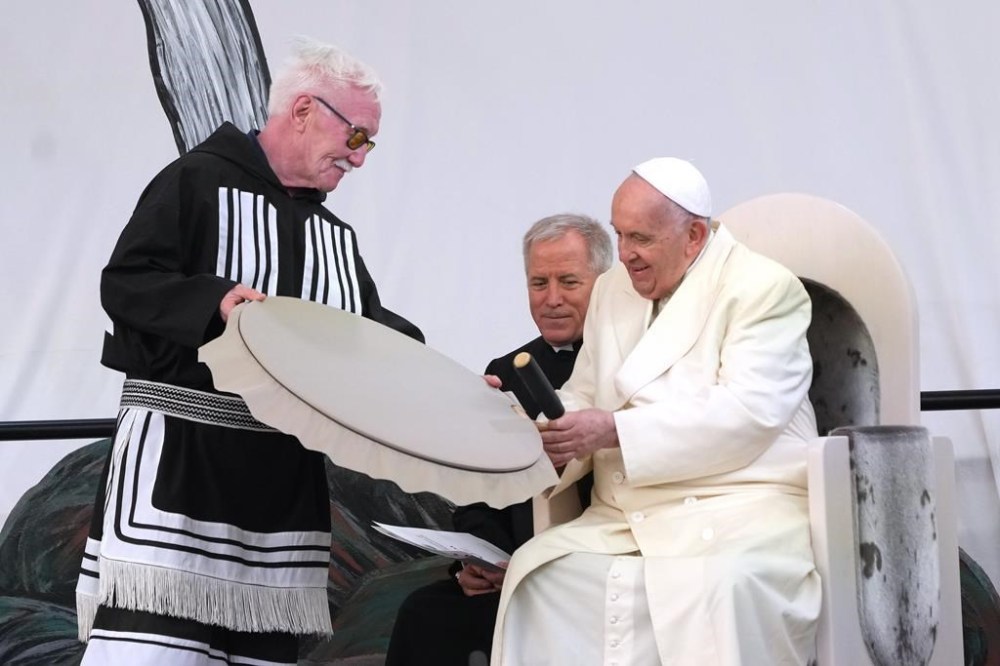 Pope Francis receives a traditional drum as a gift during a public event in Iqaluit, Nunavut on Friday, July 29, 2022, during his papal visit across Canada. THE CANADIAN PRESS/Nathan Denette
