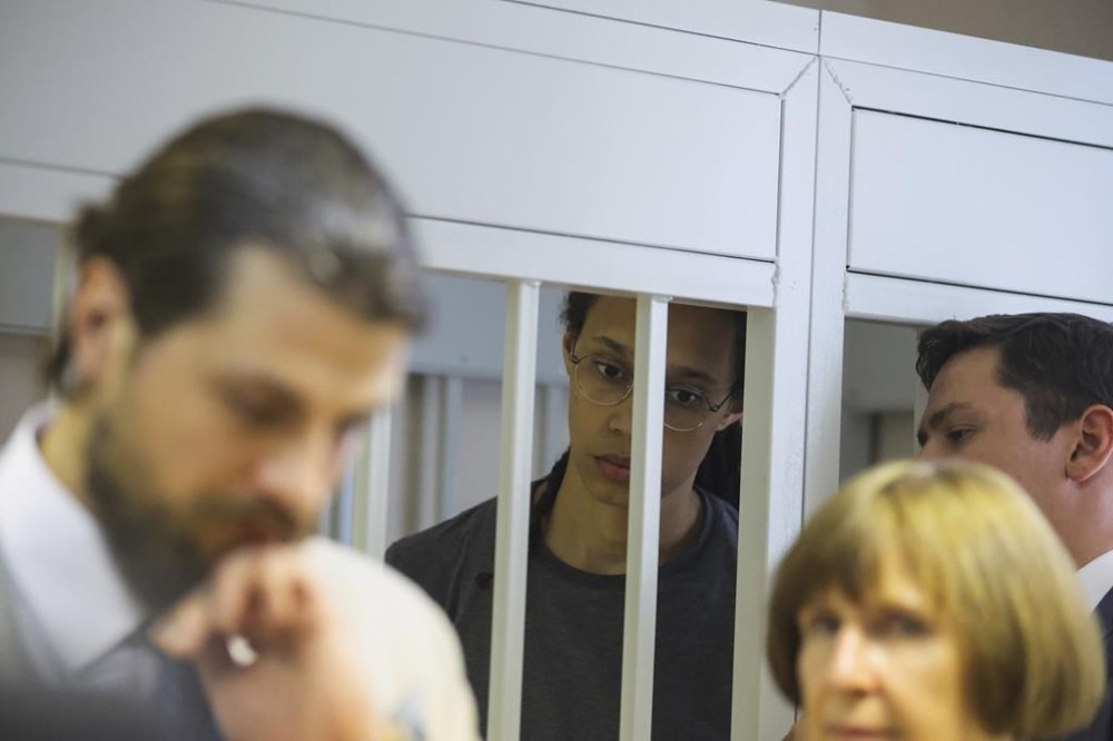 WNBA star and two-time Olympic gold medalist Brittney Griner, background center, listens to a verdict in a courtroom in Khimki just outside Moscow, Russia, Thursday, Aug. 4, 2022. American basketball star Brittney Griner apologized to her family and teams as a Russian court heard closing arguments in her drug possession trial said it expected to deliver a verdict later Thursday. (Evgenia Novozhenina/Pool Photo via AP)