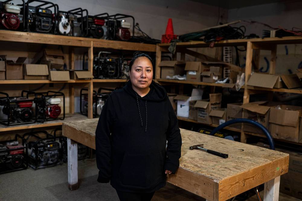 AARON VINCENT ELKAIM / THE NARWHAL
Marjorie Nielsen, who works in the housing department of Peguis First Nation, in front of a stock of sub pumps used to pump flood waters.