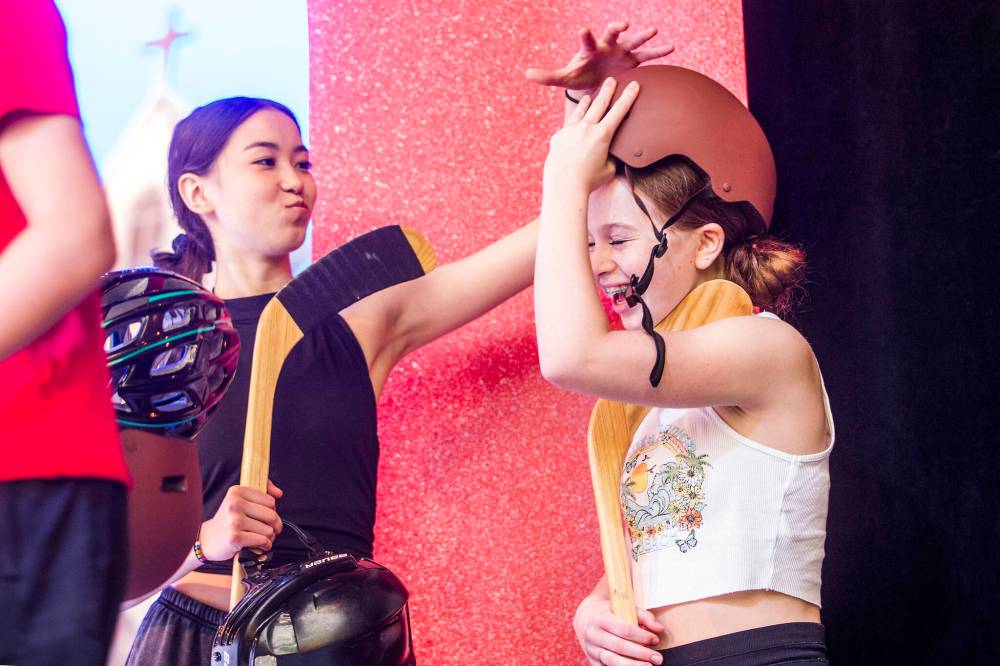 Kaelyn Yoon-MacRae (playing Marie Sirois), left, and Keara Allain (portraying Ginette Beauchamps) have a laugh while gearing up on stage for the first time during rehearsal.