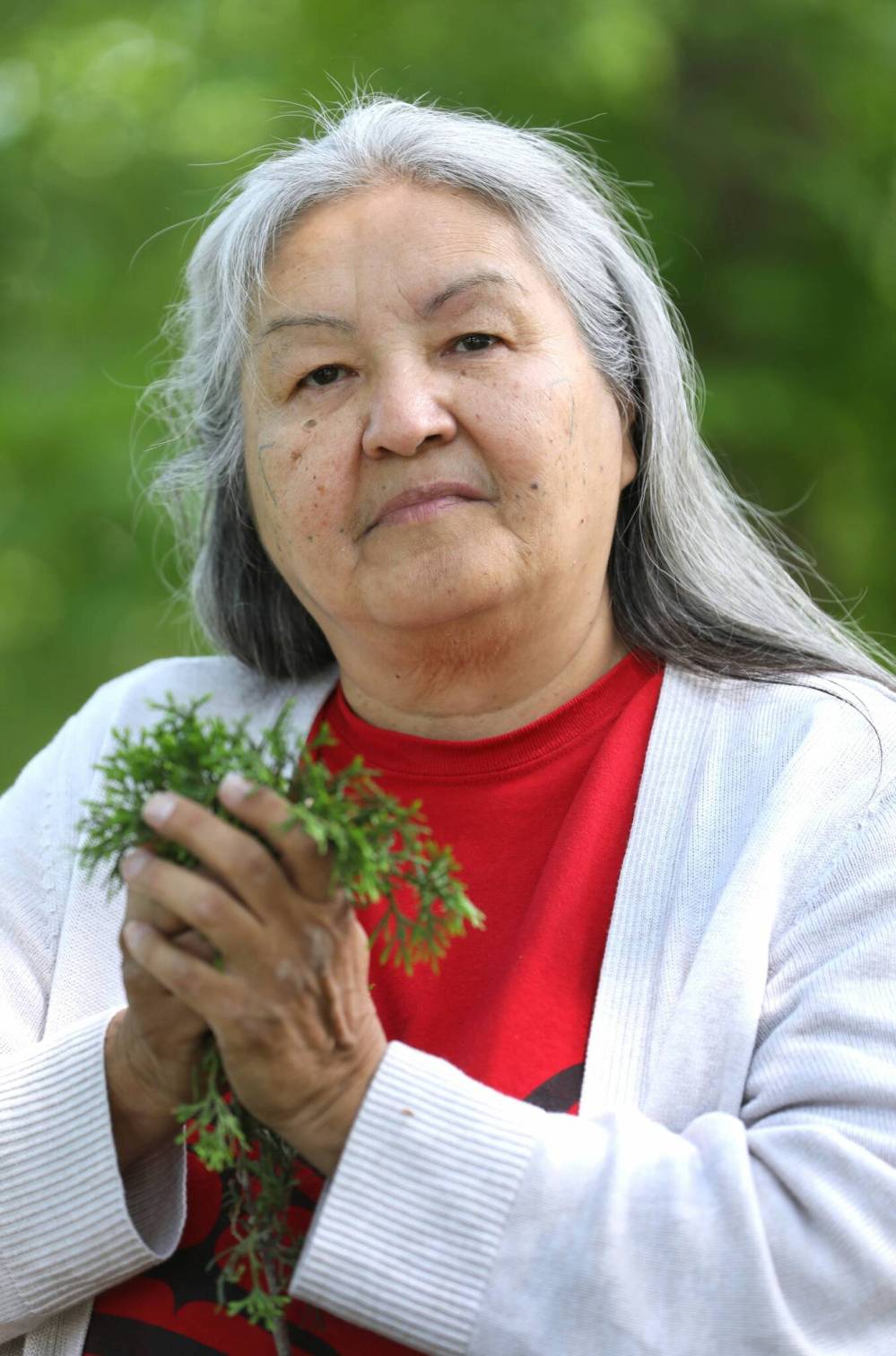 Chickadee Richard holds a bouquet of cedar, one of the medicines she gathers and uses. (Ruth Bonneville / Winnipeg Free Press)