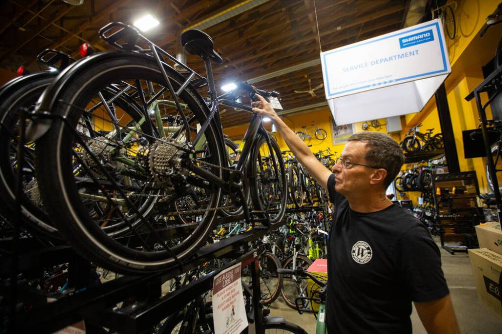 DANIEL CRUMP / WINNIPEG FREE PRESS
Tim Woodcock, owner of Woodcock Cycle Works, shows off some of the e-bikes that he stocks at his St. Vital store.