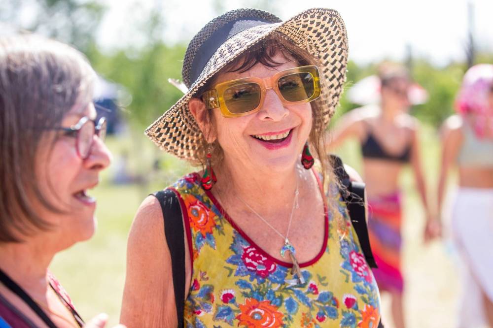 MIKAELA MACKENZIE / WINNIPEG FREE PRESS Salli Portnoy (centre) and her friend Joanne Mills pose for a photo at the Winnipeg Folk Fest in Bird’s Hill Park on Friday, July 8, 2022. For Eva Wasney fashion story. Winnipeg Free Press 2022.