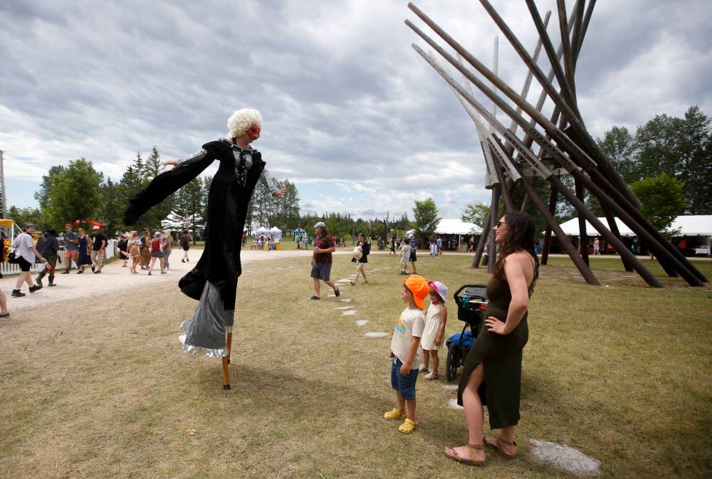 JOHN WOODS / WINNIPEG FREE PRESS
Green Fools Theatre’s Griselda, aka Judith Mendelsohn, entertains festival goers Theo, 5, Emelia, 3, Aisha Locken and baby Mija, 3.5 months on Sunday.