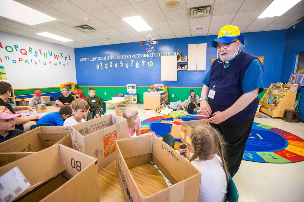 MIKAELA MACKENZIE / WINNIPEG FREE PRESS  Metropolitan Archbishop Lawrence Huculak greets a group of children at a summer camp for school-aged Ukrainian refugee children on Tuesday.