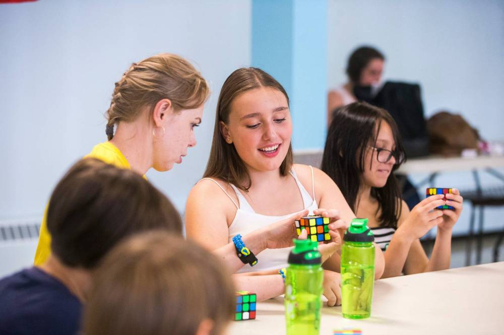 MIKAELA MACKENZIE / WINNIPEG FREE PRESS Day camp leader Alona Oliinyk (right) helps Arina Chychul, 13, solve a Rubik’s Cube.