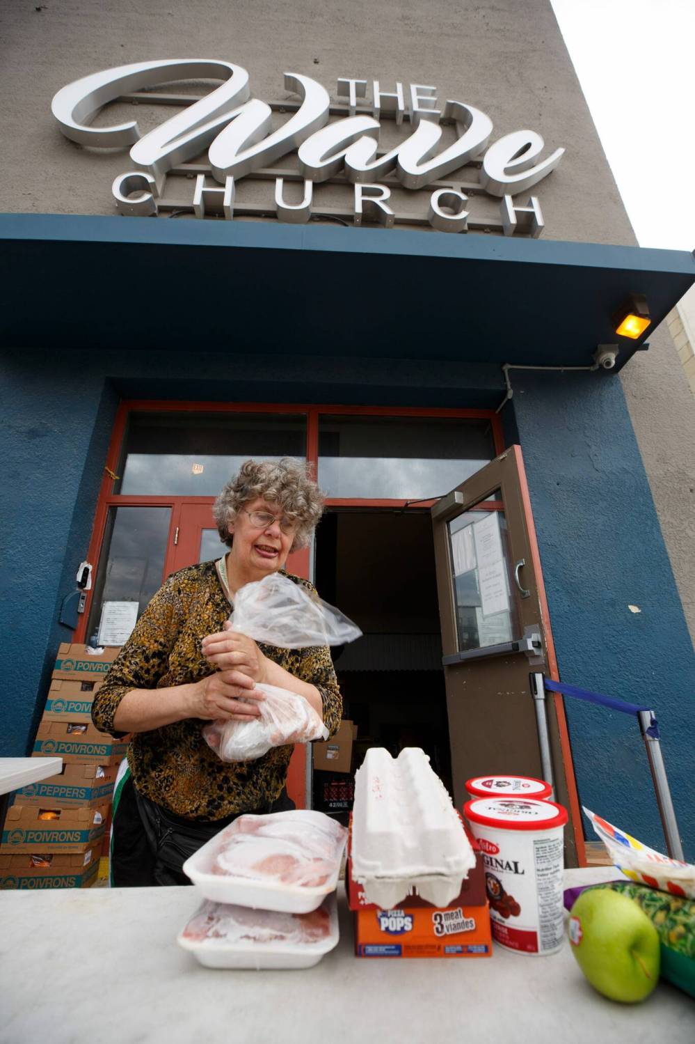 MIKE DEAL / WINNIPEG FREE PRESS
Agape Table volunteer Jackie Sakal sets out food for a customer to pick up Thursday. Skyrocketing prices are making food banks a last resort for more Winnipeggers.