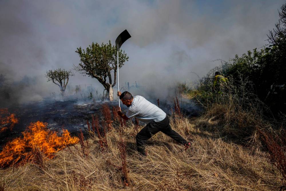 BERNAT ARMANGUE / THE ASSOCIATED PRESS FILES
A local resident fights a forest fire with a shovel during a wildfire in Tabara, north-west Spain, Tuesday, July 19, 2022. Firefighters battled wildfires raging out of control in Spain and France as Europe wilted under an unusually extreme heat wave that authorities in Madrid blamed for hundreds of deaths.