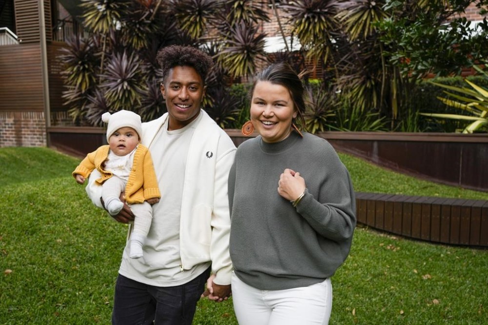 Ellia Green with his partner Vanessa Turnbull-Roberts and their daughter Waitui pose in Sydney, Australia, Monday, Aug. 15, 2022. Green, one of the stars of Australia's gold medal-winning women's rugby sevens team at the 2016 Olympics, has transitioned to male. The 29-year-old, Fiji-born Green is going public in a video at an international summit aimed at ending transphobia and homophobia in sport. The summit is being hosted in Ottawa as part of the Bingham Cup rugby tournament. (AP Photo/Mark Baker)
