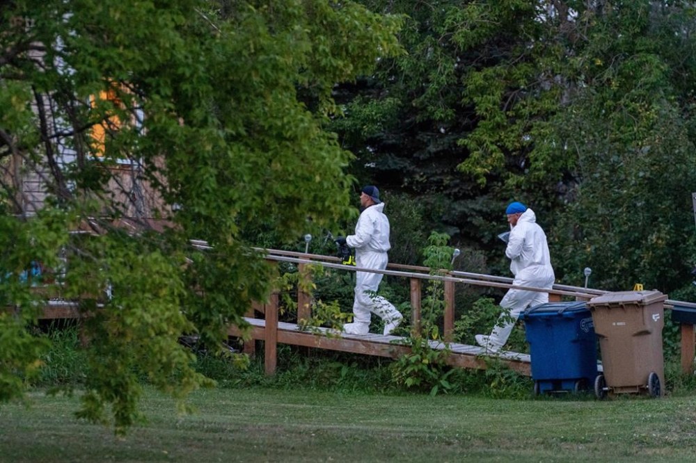 Investigators with protective equipment enter a house in a crime scene in Weldon, Sask., Sunday, Sept. 4, 2022. THE CANADIAN PRESS/Heywood Yu