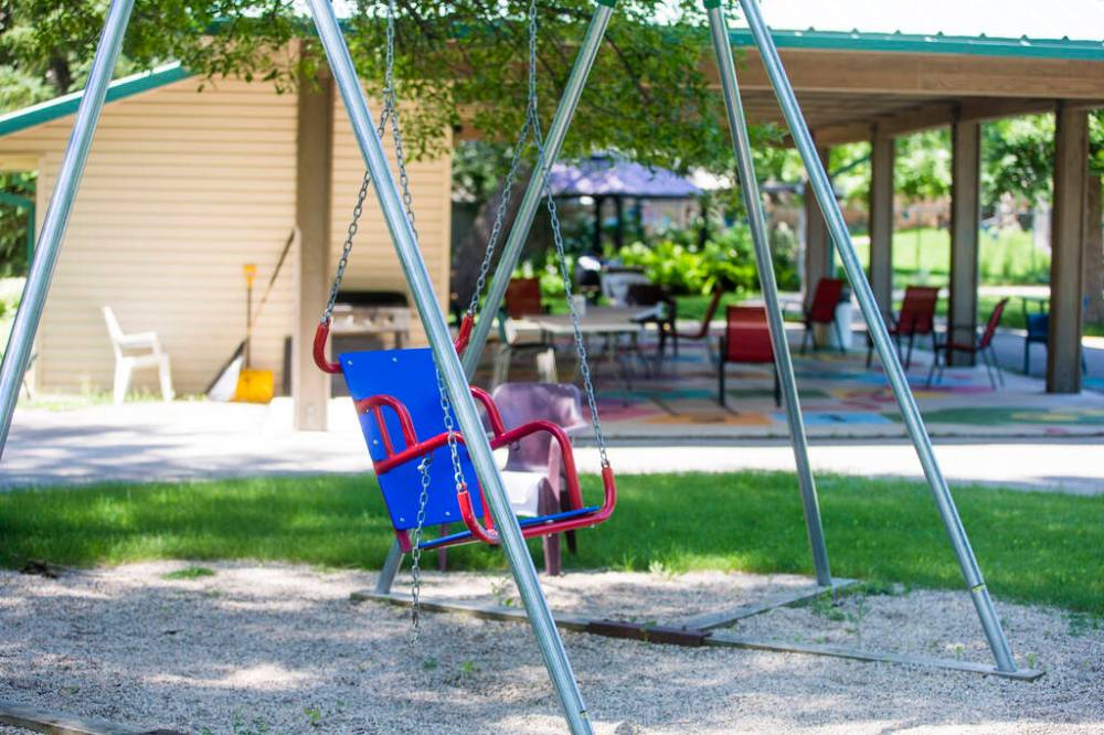 MIKAELA MACKENZIE / WINNIPEG FREE PRESS
An adaptive swing in the Buhler Gardens at St. Amant Centre. The old brick buildings and sprawling space suggest a campus-like setting.
