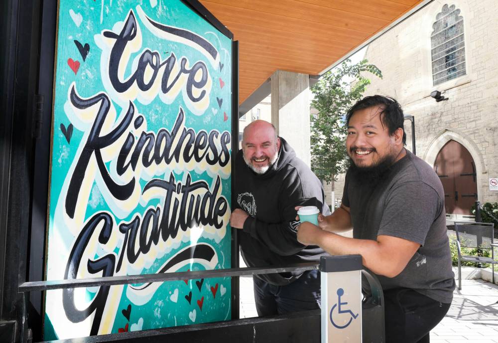 RUTH BONNEVILLE / WINNIPEG FREE PRESS
                                ‘Of course I was angry when I saw it but really I feel bad for the person that did this,’ says Harrisons Coffee owner Al Dawson (left), with artist Joseph Pilapil who painted the artwork to cover the gap. ‘The way I look it, the person who did this was in a lot of pain.’