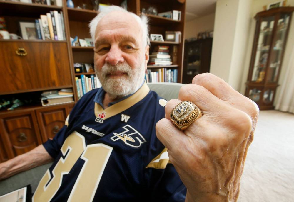 JOHN WOODS / WINNIPEG FREE PRESS Former Winnipeg Blue Bomber Ron (Pepe) Latourelle and one of the last surviving members of the 1960 team is photographed in his home in Winnipeg Tuesday, August 16, 2021. Latourelle won 4 Grey Cups and was inducted into the Manitoba Football and Blue Bomber Halls of Fame. Latourelle looks through photos of teammates and shows off a championship/Hall of Fame ring he received in 2007.