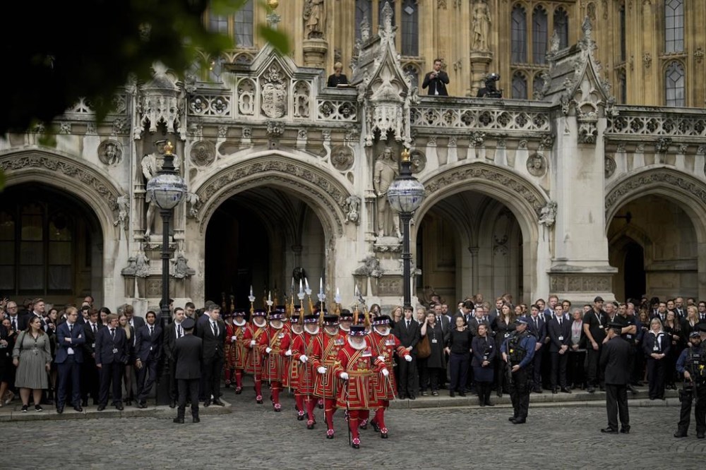 Yeomen Warders march out of Westminster Hall, in the Palace of Westminster, where the House of Commons and the House of Lords meet to express their condolences in London, Monday, Sept. 12, 2022. Queen Elizabeth II, Britain's longest-reigning monarch and a rock of stability across much of a turbulent century, died Thursday Sept. 8, 2022, after 70 years on the throne. She was 96. (AP Photo/Markus Schreiber, Pool)