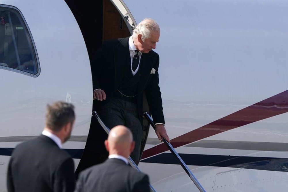 King Charles III arrives at Edinburgh Airport after travelling from London with Camilla, the Queen Consort, ahead of joining the procession of the late Queen's coffin from the Palace of Holyroodhouse to St Giles' Cathedral, Edinburgh, Monday, Sept. 12, 2022. Queen Elizabeth II, Britain's longest-reigning monarch and a rock of stability across much of a turbulent century, died Thursday Sept. 8, 2022, after 70 years on the throne. She was 96. (Owen Humphreys/Pool Photo via AP)
