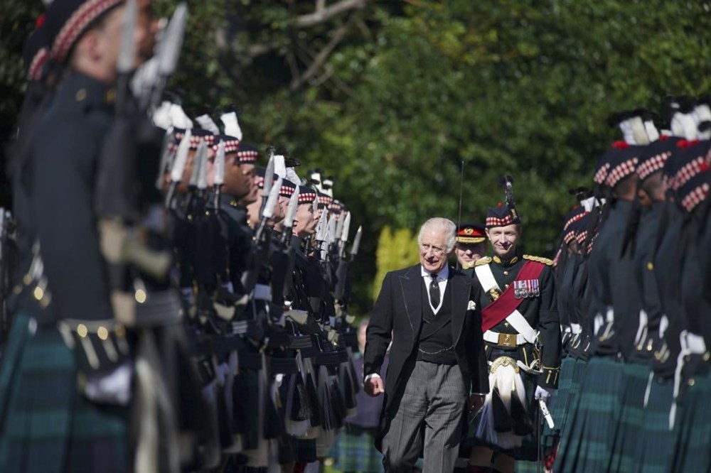King Charles III inspects the Guard of Honour as he arrives to attend the Ceremony of the Keys, at the Palace of Holyroodhouse, Edinburgh, Monday, Sept. 12, 2022. Queen Elizabeth II, Britain's longest-reigning monarch and a rock of stability across much of a turbulent century, died Thursday Sept. 8, 2022, after 70 years on the throne. She was 96. (Peter Byrne/Pool Photo via AP)
