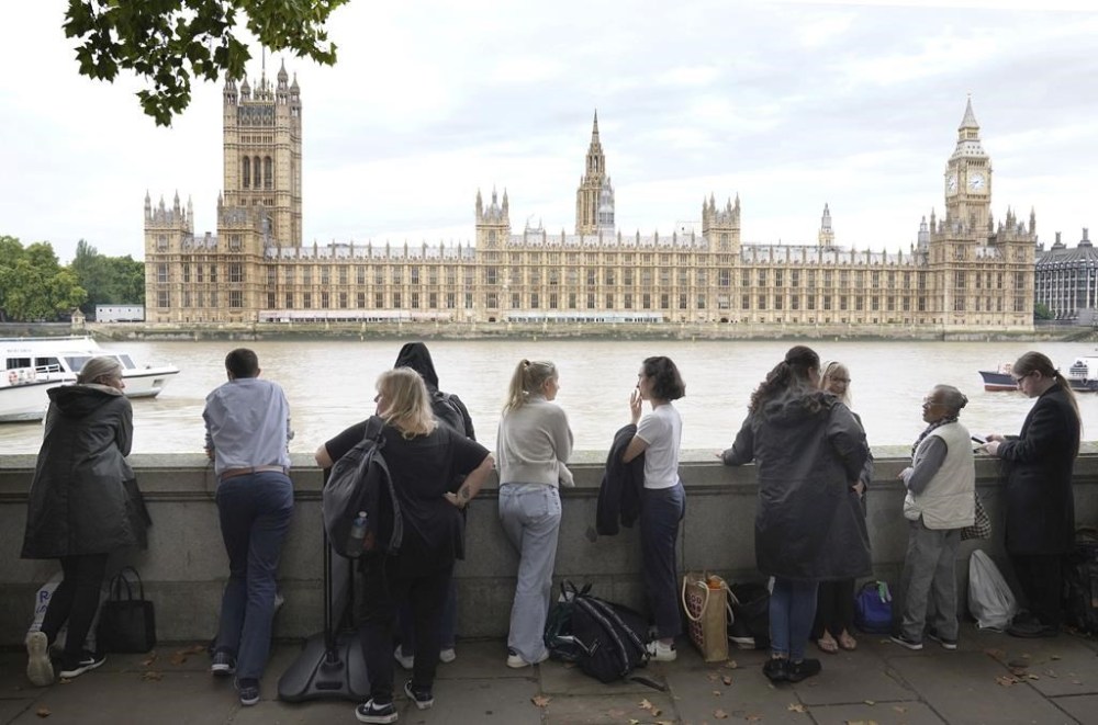 Members of the public join the queue on the South Bank, as they wait to view Queen Elizabeth II lying in state ahead of her funeral, in London, Wednesday Sept. 14, 2022. (Stefan Rousseau/PA via AP)