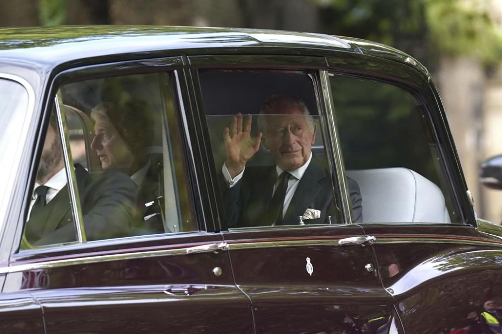 King Charles III waves as he leaves Clarence House ahead of the ceremonial procession of the coffin of Queen Elizabeth II, from Buckingham Palace to Westminster Hall, in London, Wednesday Sept. 14, 2022. The Queen will lie in state in Westminster Hall for four full days before her funeral on Monday Sept. 19. (Stefan Rousseau/Pool Photo via AP)