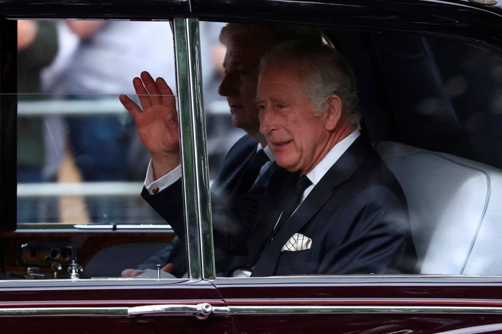 King Charles III waves as he arrives at Buckingham Palace ahead of the ceremonial procession of the coffin of Queen Elizabeth II, from Buckingham Palace to Westminster Hall, in London, Wednesday Sept. 14, 2022. The Queen will lie in state in Westminster Hall for four full days before her funeral on Monday Sept. 19. (Tom Nicholson/Pool Photo via AP)