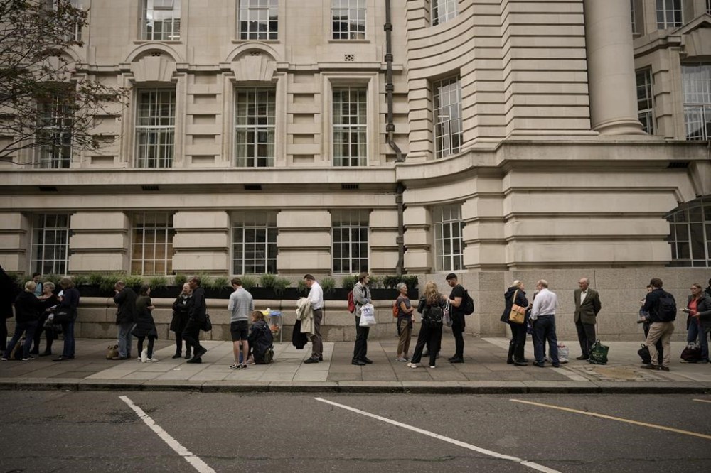 People queue in line to bid farewell to Queen Elizabeth II in London, Wednesday, Sept. 14, 2022. Queen Elizabeth II, Britain's longest-reigning monarch and a rock of stability across much of a turbulent century, died Thursday Sept. 8, 2022, after 70 years on the throne, at the age of 96. (AP Photo/Andreea Alexandru)