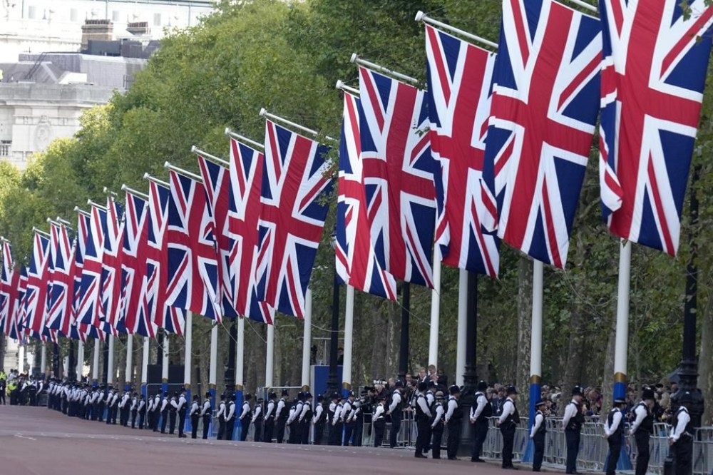 Police and Union Flags line the route along The Mall prior to the procession which will carry the coffin of Queen Elizabeth II from Buckingham Palace to Westminster Hall in London, Wednesday, Sept. 14, 2022. The Queen will lie in state in Westminster Hall for four full days before her funeral on Monday Sept. 19. (AP Photo/Kirsty Wigglesworth)