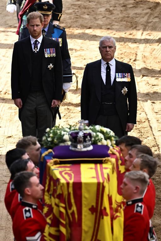 Britain's Prince Harry and Britain's Prince Andrew walk behind the coffin of Queen Elizabeth II, adorned with a Royal Standard and the Imperial State Crown, as the coffin is carried into the Palace of Westminster, following a procession from Buckingham Palace, in London, Wednesday, Sept. 14, 2022. (Ben Stansall/Pool via P)