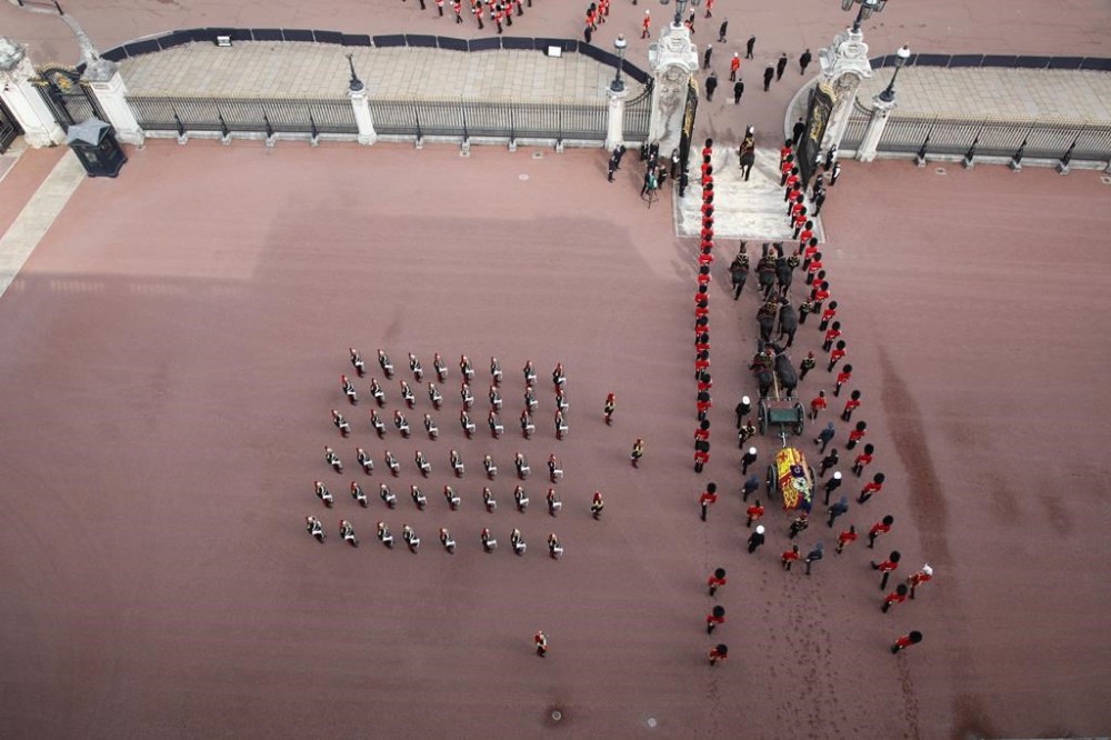 Members of the armed forces walk in formation near the coffin of Queen Elizabeth II, adorned with a Royal Standard and the Imperial State Crown, before a procession from Buckingham Palace to Westminster Hall in London, Wednesday, Sept. 14, 2022. The Queen will lie in state in Westminster Hall for four full days before her funeral on Monday Sept. 19. (Lee Goddard/Ministry of Defense via AP)