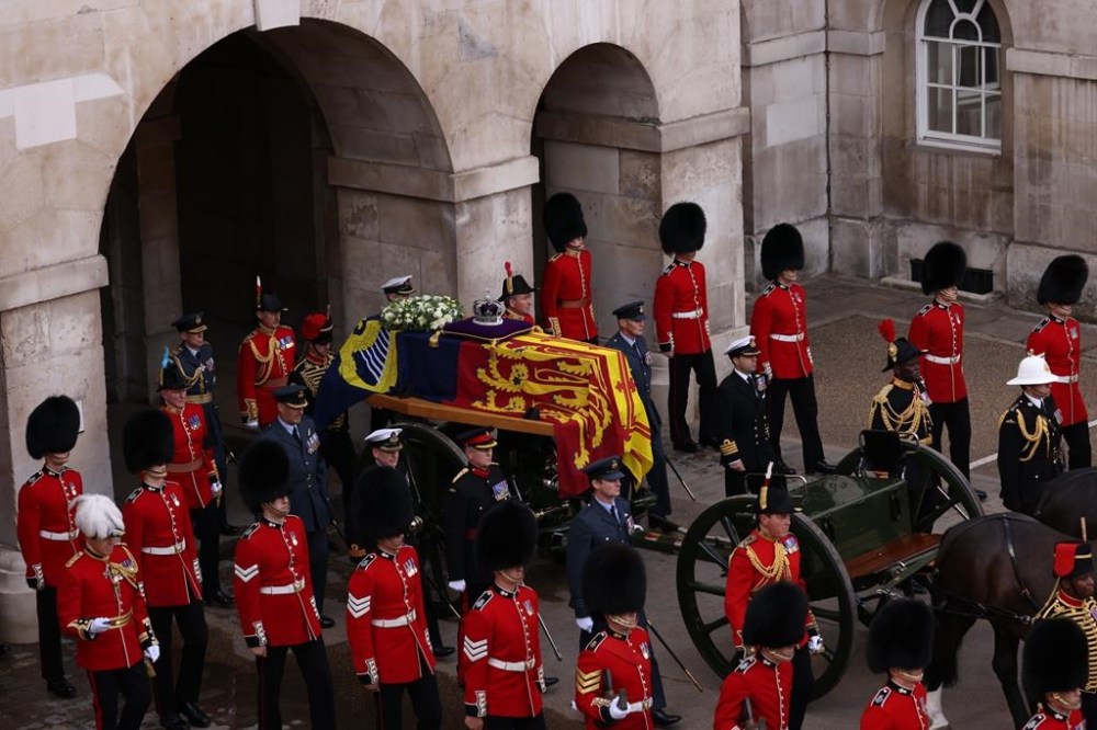 Members of the armed forces move the coffin of Queen Elizabeth II, adorned with a Royal Standard and the Imperial State Crown, during a procession from Buckingham Palace to Westminster Hall in London, Wednesday, Sept. 14, 2022. The Queen will lie in state in Westminster Hall for four full days before her funeral on Monday Sept. 19. (Rebecca Brown/Ministry of Defense via AP)