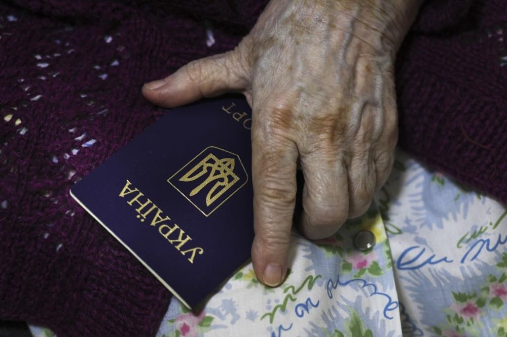 An elderly woman from Luhansk region, the territory controlled by a pro-Russia separatist government, but who lives in Russia, holds her Ukrainian passport as she prepares to vote at temporary accommodation facility in Volgograd, Russia, Friday, Sept. 23, 2022. Voting began Friday in four Moscow-held regions of Ukraine on referendums to become part of Russia. Polls also opened in Russia, where refugees from regions under Russian control can cast their votes. (AP Photo)