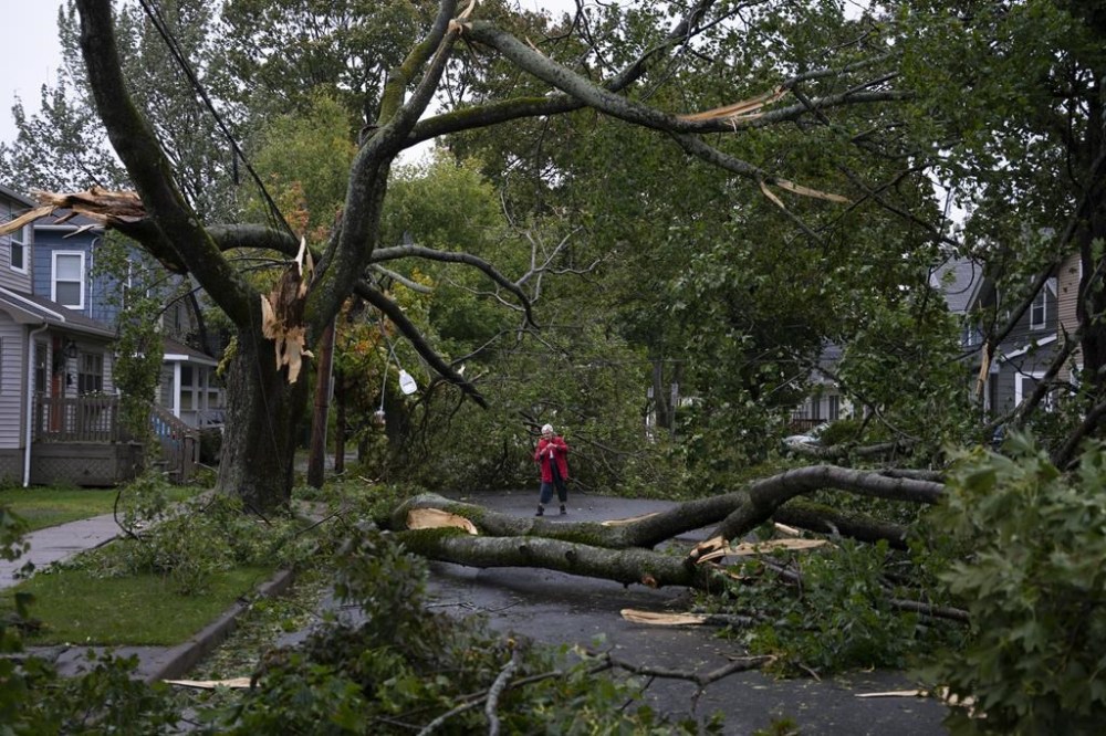 Georgina Scott surveys the damage on her street in Halifax as post tropical storm Fiona continues to batter the Maritimes on Saturday, September 24, 2022. THE CANADIAN PRESS/Darren Calabrese