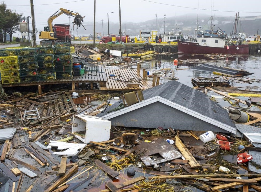 Heavy machinery clears up washed-up buildings and rubble in the harbour in Burnt Islands, N.L., on Tuesday, Sept. 27, 2022. Fiona left a trail of destruction across much of Atlantic Canada, stretching from Nova Scotia's eastern mainland to Cape Breton, Prince Edward Island and southwestern Newfoundland. THE CANADIAN PRESS/Frank Gunn