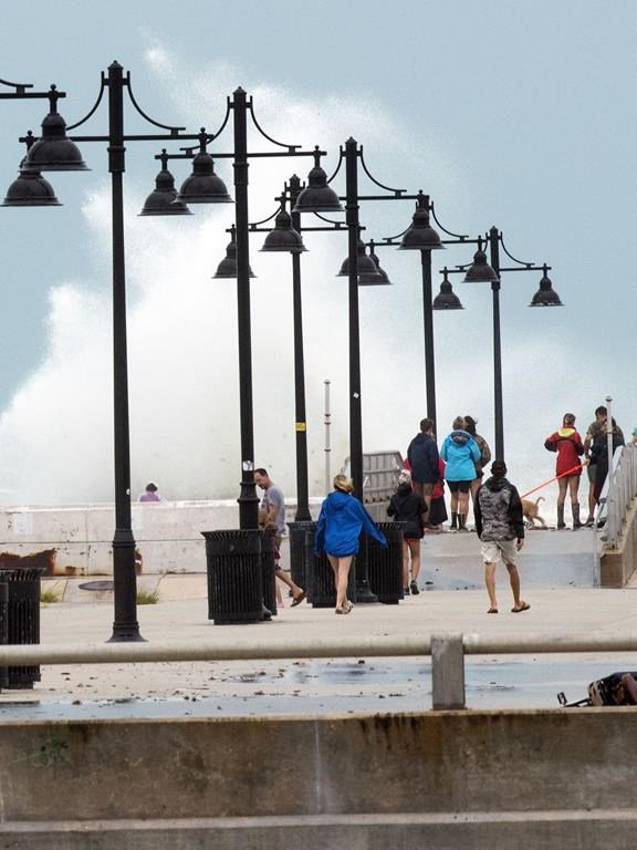 Tourists and residents stroll White Street pier, Tuesday, Sept. 27, 2022, in Key West, Fla. Hurricane Ian was forecast to strengthen even more over warm Gulf of Mexico waters, reaching top winds of 140 mph (225 kmh) as it approaches the Florida's southwest coast. (AP Photo/Mary Martin)