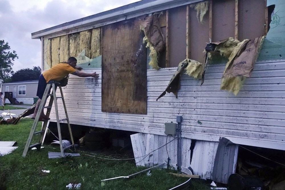 Ivan Mendoza begins to repair damage at his mobile home in Davie, Fla., early Wednesday, Sept. 28, 2022. Hurricane Ian rapidly intensified off Florida's southwest coast Wednesday morning, gaining top winds of 155 mph (250 kph), just shy of the most dangerous Category 5 status. (Joe Cavaretta/South Florida Sun-Sentinel via AP)