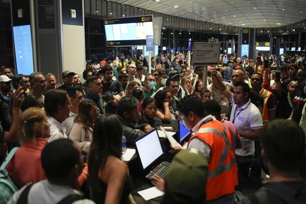 Passenger try to reschedule their flights after many were cancelled or delayed due to Hurricane Ian, at Tocumen International Airport in Panama City, Tuesday, Sept. 27, 2022. Hurricane Ian tore into western Cuba as a major hurricane and left 1 million people without electricity, then churned on a collision course with Florida over warm Gulf waters amid expectations it would strengthen into a catastrophic Category 4 storm. (AP Photo/Matias Delacroix)