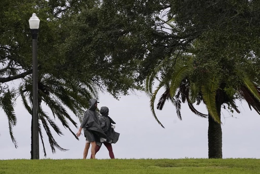 A couple walks along the waterfront that is seeing the effects of Hurricane Ian Wednesday, Sept. 28, 2022, in Saint Petersburg, Fla. (AP Photo/Steve Helber)