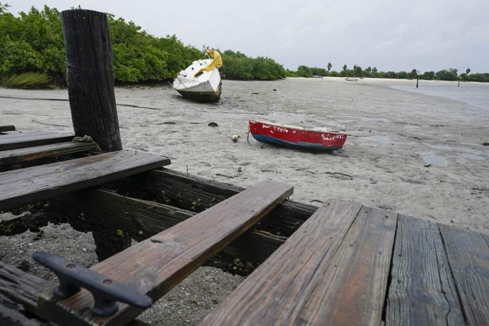 Boats in Tampa Bay lie in the mud as water is receding from the bay ahead of Hurricane Ian, Wednesday, Sept. 28, 2022, in Tampa, Fla. (AP Photo/Chris O'Meara)