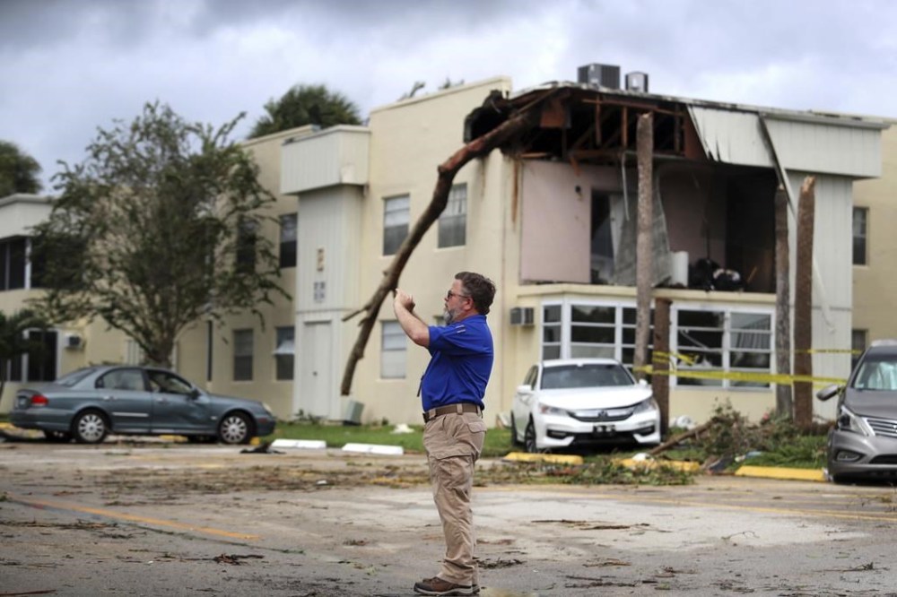 David Dellinger with the National Weather Service, surveys the damage from an apparent overnight tornado spawned from Hurricane Ian at Kings Point 55+ community in Delray Beach, Fla., on Wednesday, Sept. 28, 2022. (Carline Jean /South Florida Sun-Sentinel via AP)