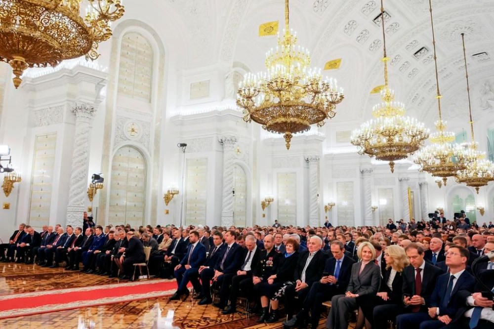 Participants listen to Russian President Vladimir Putin during celebrations marking the incorporation of regions of Ukraine to join Russia in the Kremlin in Moscow, Russia, Friday, Sept. 30, 2022. The signing of the treaties making the four regions part of Russia follows the completion of the Kremlin-orchestrated