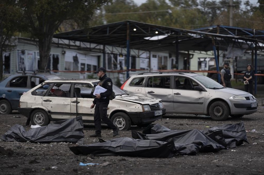 A Ukrainian police officer walks past bags containing the bodies of people who died after a Russian attack in Zaporizhzhia, Ukraine, Friday, Sept. 30, 2022. (AP Photo/Leo Correa)