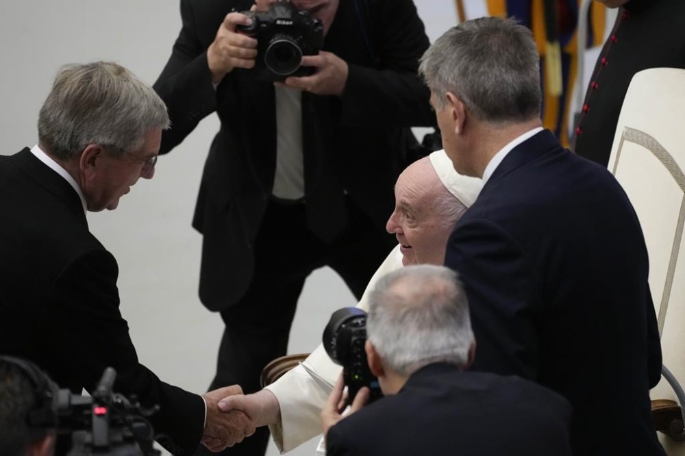 Thomas Bach, President of the International Olympic Committee, left, greets Pope Francis during an audience the Pontiff granted to the participants of the
