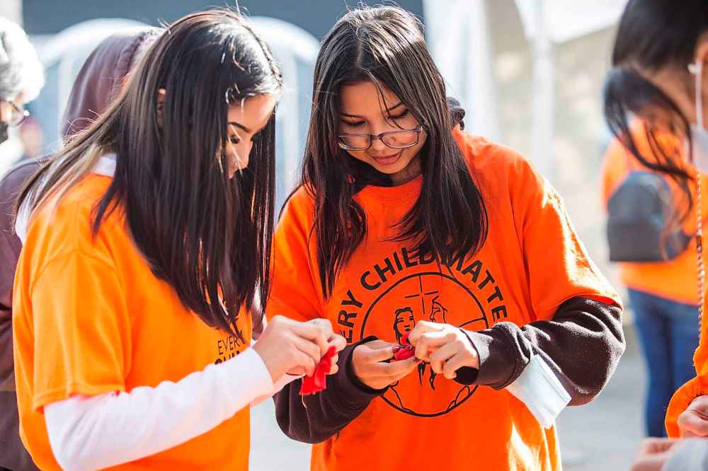 Mia Wastesicoot, 15 (left), and Sierra Wastesicoot, 16, make tobacco ties at Ma Mawi Wi Chi Itata Centre on the National Day for Truth and Reconciliation in Winnipeg. (Mikaela MacKenzie / Winnipeg Free Press)