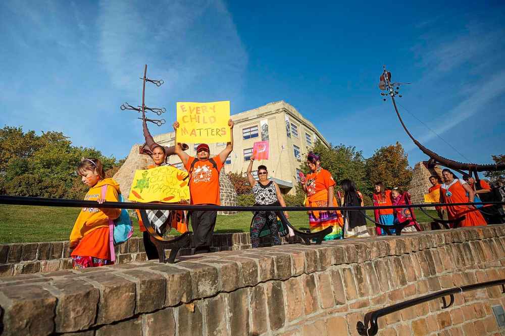 Gerald Abraham, whose traditional name is Blackcloud, from Little Black River First Nation, holds up a sign reading, ”Every Child Matters” Friday morning at The Forks. (Mike Deal / Winnipeg Free Press)