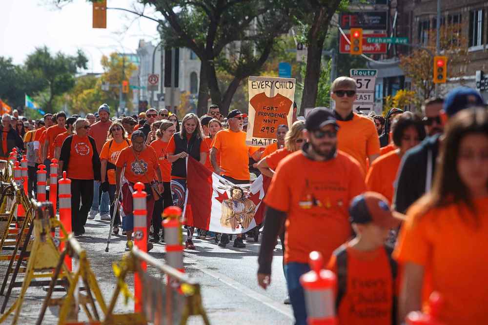 Hundreds of people take part in the march to the RBC Convention Centre from The Forks on Friday. (Mike Deal / Winnipeg Free Press)