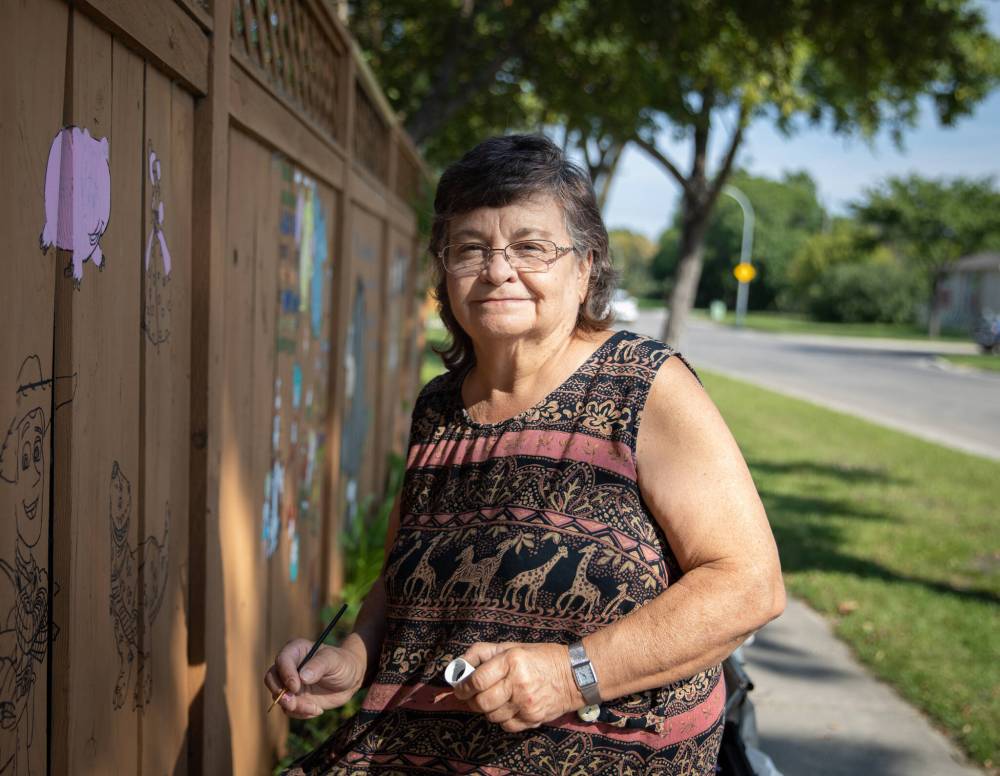 JESSICA LEE / WINNIPEG FREE PRESS
Fran Doyle takes a break while painting her fence. She began painting her fence with recognizable characters from movies, books and TV shows in an effort to cheer up passersby.