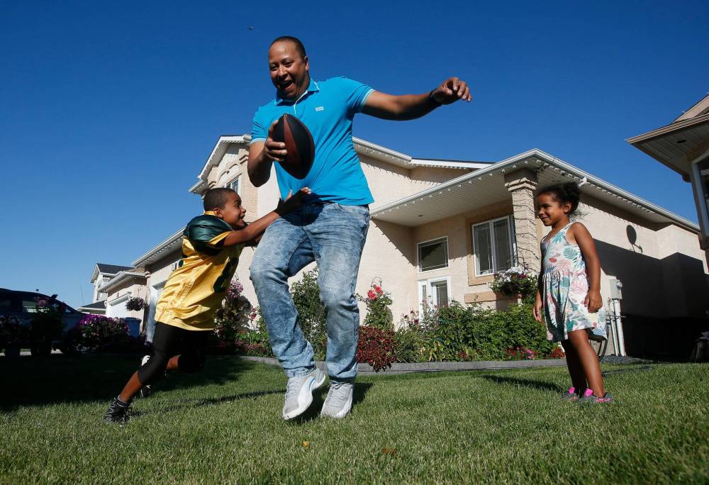 JOHN WOODS / WINNIPEG FREE PRESS Greg McFarlane plays football with his children Charlize, 4, and Christian, 8 outside their Seven Oaks home in Winnipeg Tuesday, September 6, 2022. McFarlane, chairperson of the Seven Oaks board of trustees, is optimistic about the new school year. Re: Macintosh