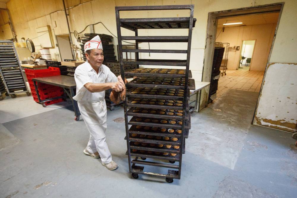MIKE DEAL / WINNIPEG FREE PRESS
Bakery foreman Thuan Nguyen moves some freshly baked muffins off to the side to cool.