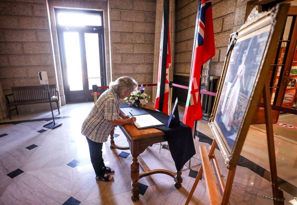RUTH BONNEVILLE / WINNIPEG FREE PRESS
Bonnie Forest signs the book of condolences Monday afternoon.