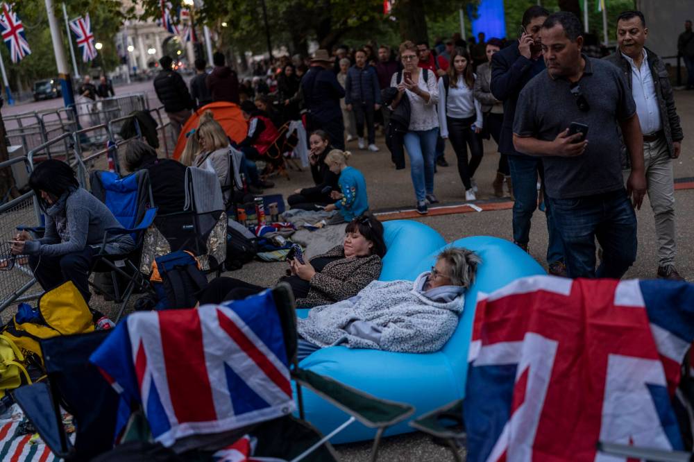 BERNAT ARMANGUE / THE ASSOCIATED PRESS
People camp out on The Mall on the eve of the funeral of Queen Elizabeth in London, Sunday. The funeral of Elizabeth, Britain’s longest-reigning monarch, takes place Monday.