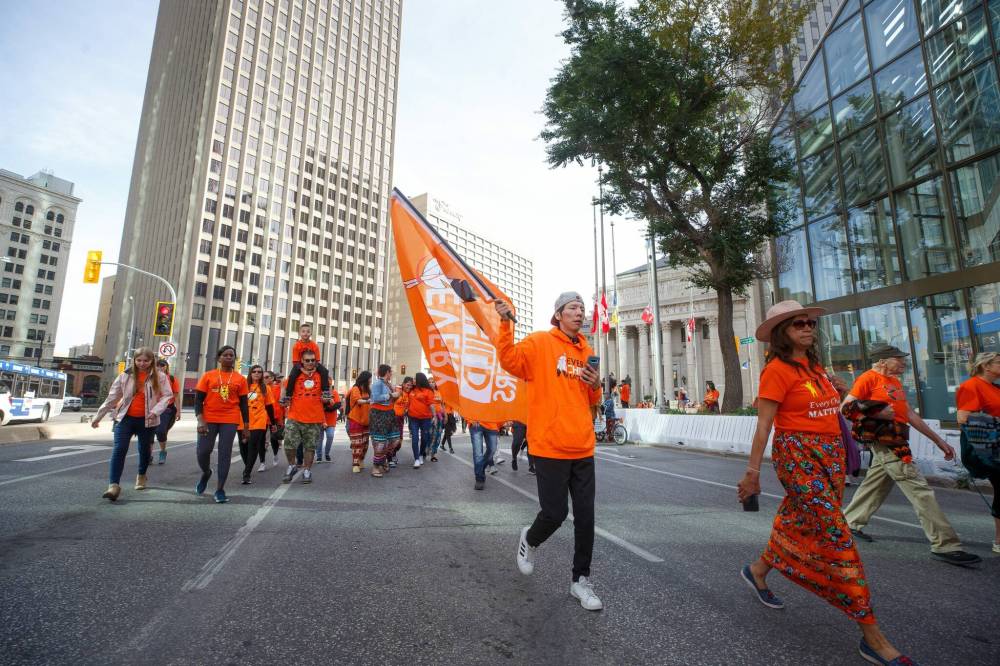 Hundreds of people take part in the march towards the RBC Convention Centre from The Forks Friday morning. (Mike Deal / Winnipeg Free Press)